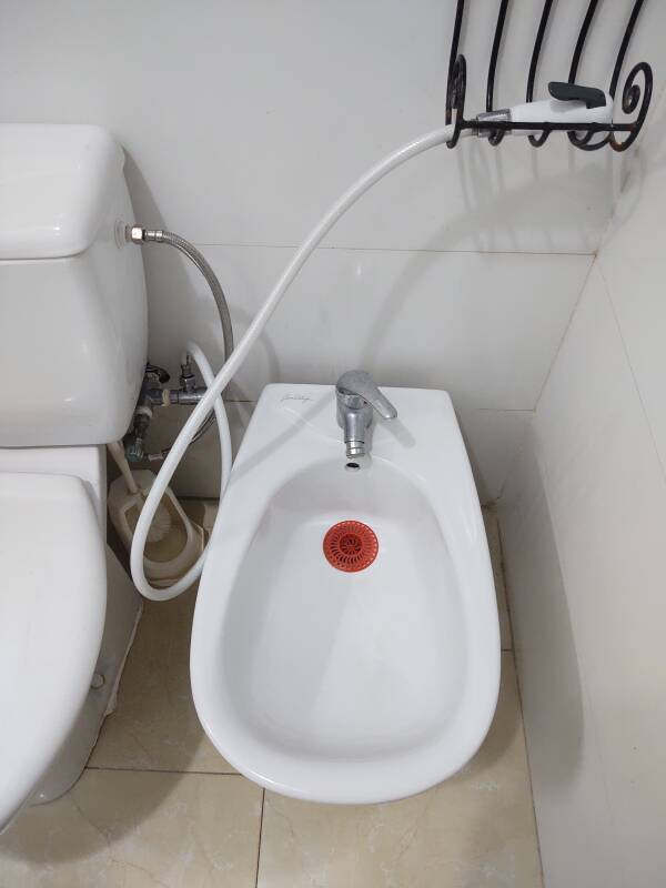 Toilet and bidet in my room at the Hotel Moroccan House in Casablanca. A shattaf, a sprayer on a hose, is connected to the toilet.