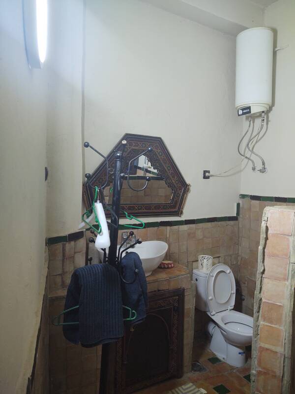 Mirror, sink, toilet, and hot water heater at a riad-style guesthouse in the medina in Meknès.