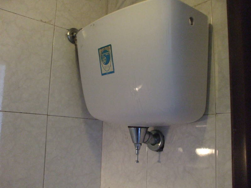 Wall-mounted toilet flush tank in Italy.