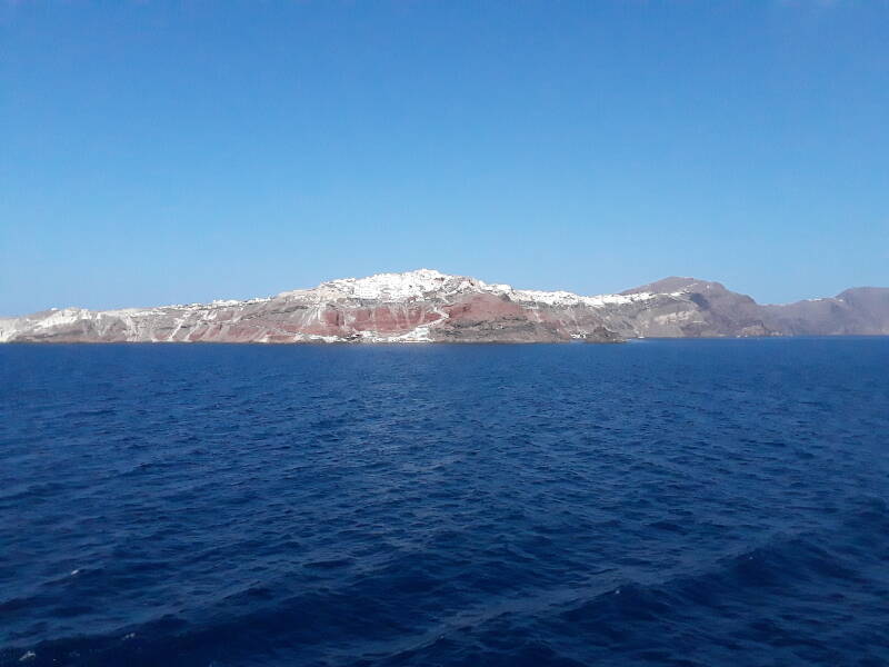Multi-colored rock and tephra layers seen from a ferry in the Santorini caldera.