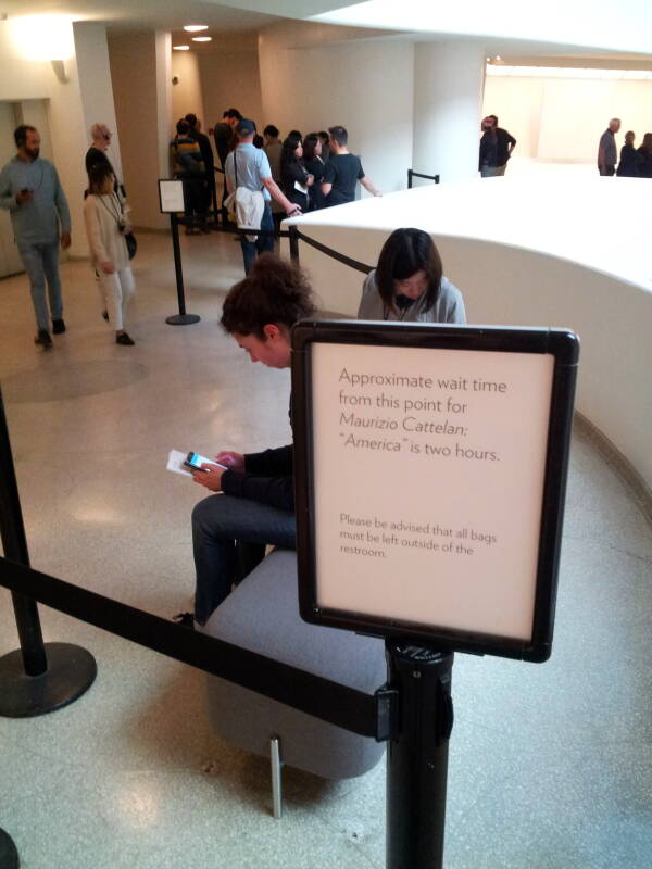 Sign for the waiting line to use the solid gold toilet 'America' Fluxus artwork at the Guggenheim Museum in New York.