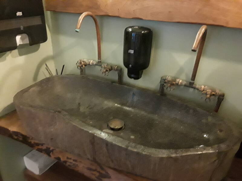 Soapstone double sink with copper faucets and fittings in a cafe in the main square in Skala on Patmos.