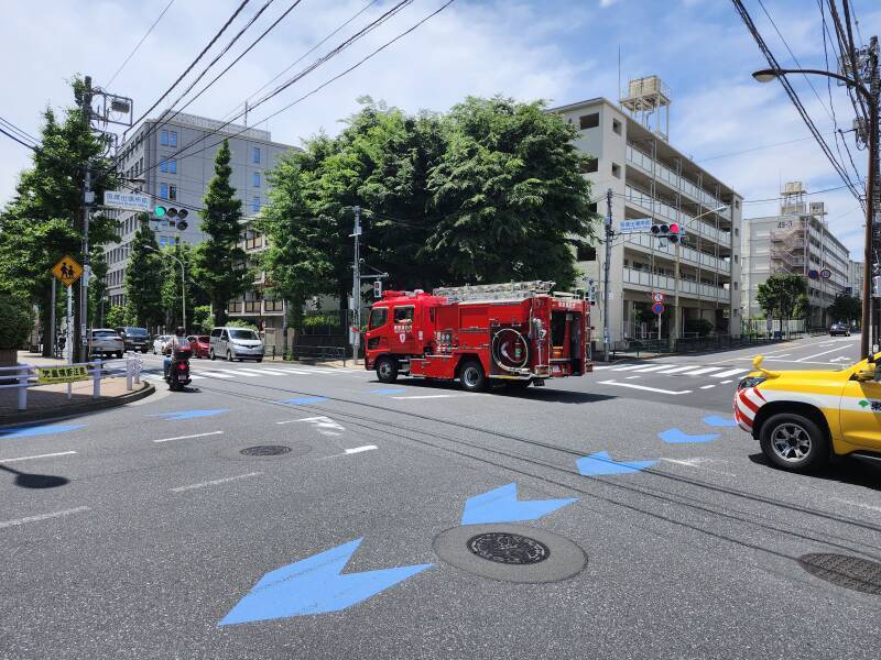 A second fire truck passes through the intersection from north to south.