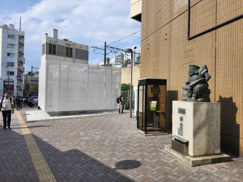 Exiting the north end of the west exit of Ebisu Station. A statue of the deity Ebisu is just outside the exit, then a phone booth, then the public toilet, and then the koban or neighborhood police station.