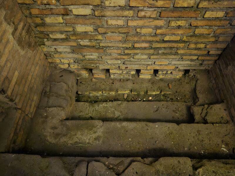 Drain within a brick arch with a modern railing added.