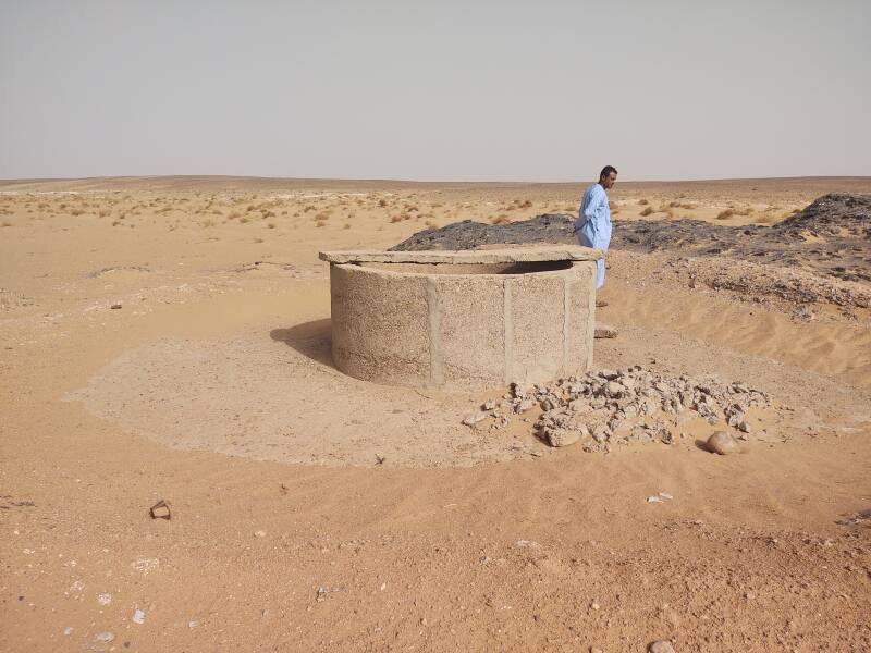 Ibrahim in a blue djellaba at a government well in the Sahara desert.