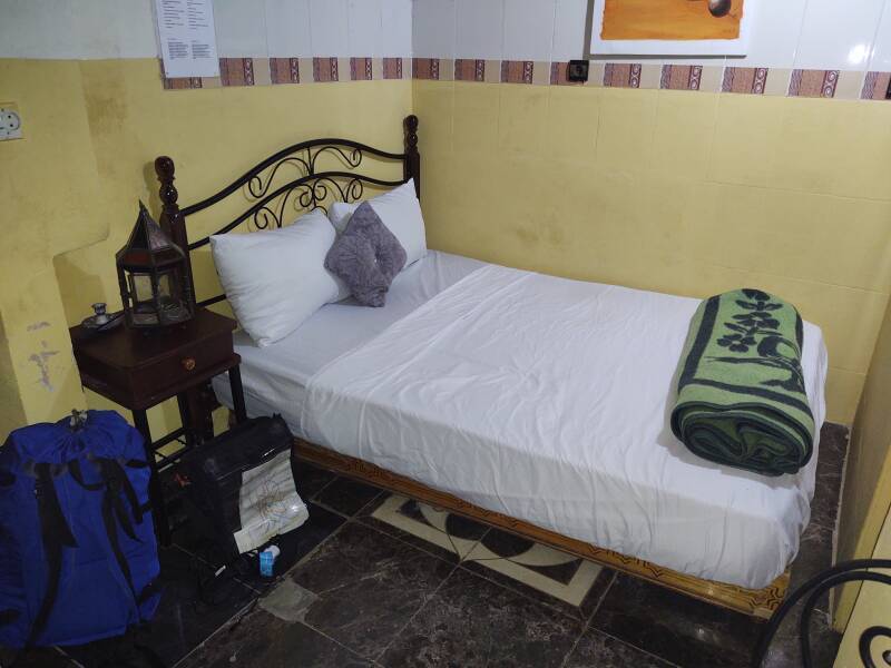 My room in the Fez el Bali medina: bed, table, lamp, backpack.