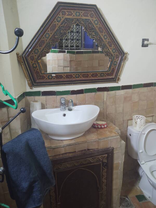 Mirror, sink, and toilet at a riad-style guesthouse in the medina in Meknès.