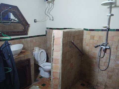Sink, toilet, hot water heater, and shower in a riad in the medina in Meknès.