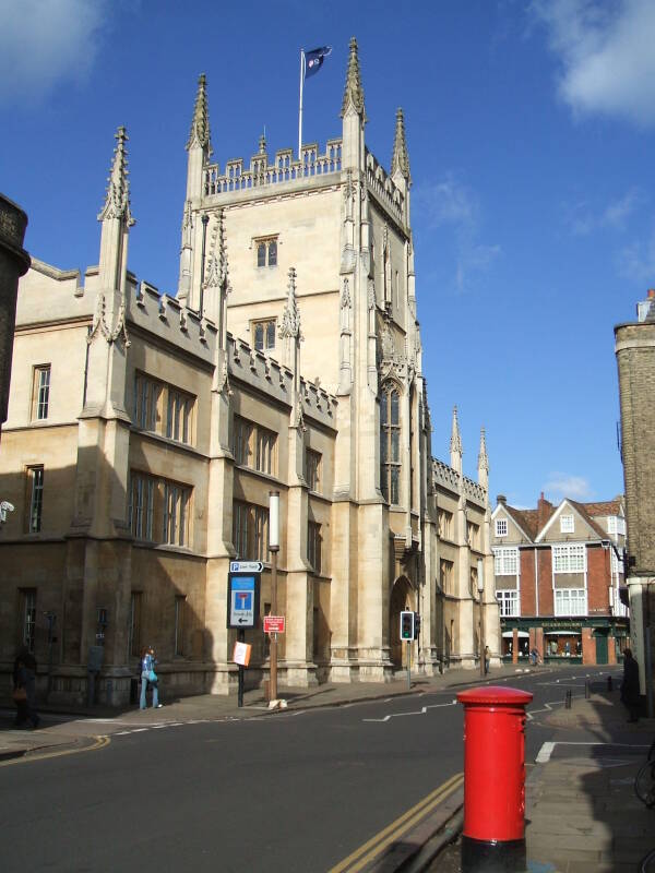 Red British post column and a limestone building of Cambridge.