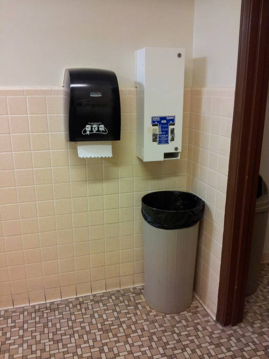 Unisex restroom with paper towel dispenser, tampon dispenser, and trash can in the Electrical Engineering building at Purdue University.