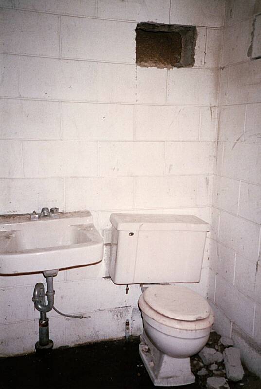 Conventional toilet and sink plumbed into a small town's municipal water and sewage system inside an early 1960s fallout shelter as it appeared in 1995.