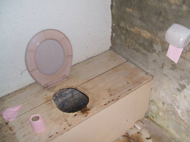 Primitive toilet behind a church in a village in Normandy.