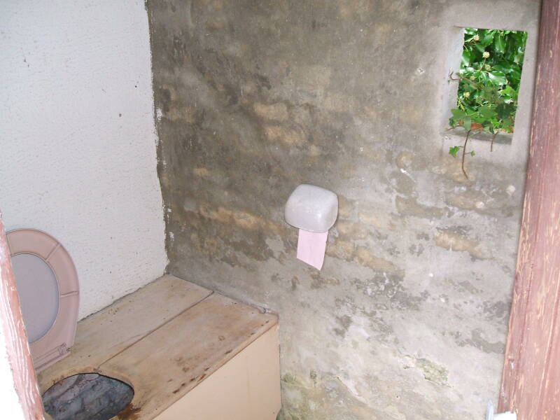 A primitive toilet behind the church in Normandy.