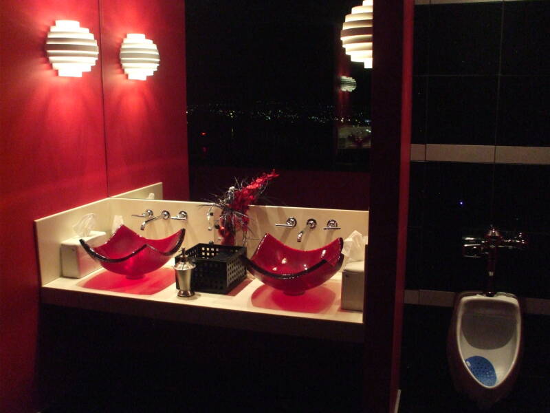 Urinal and red glass vessel sinks in the Galt House in Louisville, Kentucky.