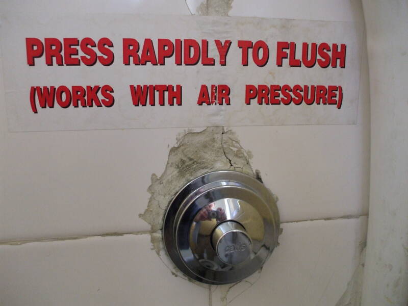 'Press rapidly to flush (works with air pressure)' -- Sign above a typical Greek toilet in the Students' and Travelers' Inn, in Athens.