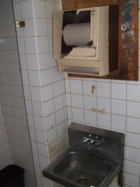 Sink and broken towel dispenser in Harry's Chocolate Shop, West Lafayette, Indiana.