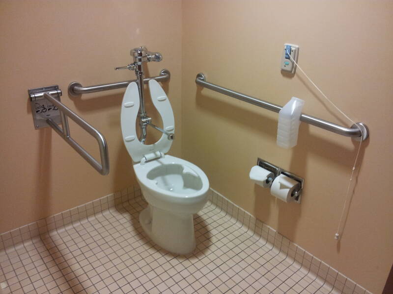 Hospital toilet with rails and call cord.