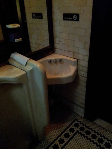 Urinal and sink inside Old Town Bar on 18th Street in the Flatiron District.