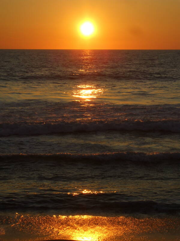 Sun setting over Pacific Ocean as seen from Venice Beach, California.