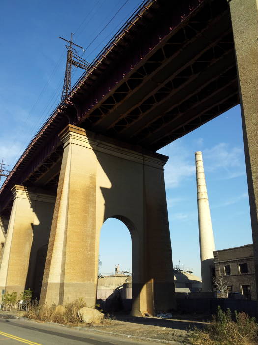 Wards Island Wastewater Treatment Plant seen underneath the Hell Gate railway bridge.