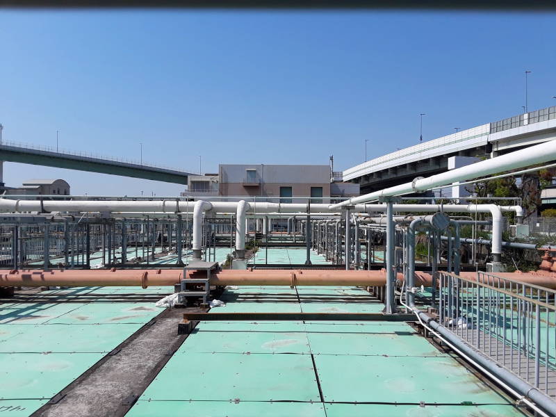 Covered sedimentation and aeration tanks and overhead pipes at the Ebie Sewage Treatment Plant in Osaka.