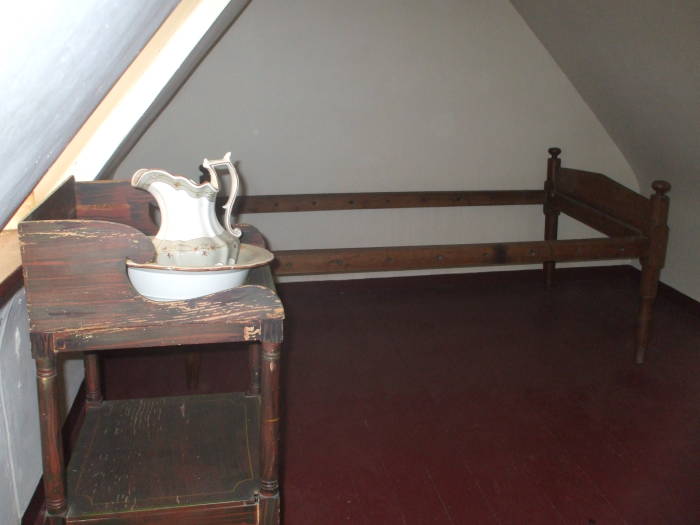 Washbasin in Edgar Allan Poe's bedroom in Baltimore.  Ceramic bowl and pitcher in a wooden stand with a large hole.