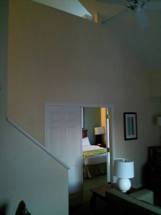 Hotel suite: couch, door to bedroom, stairway to upper bedroom and bath.