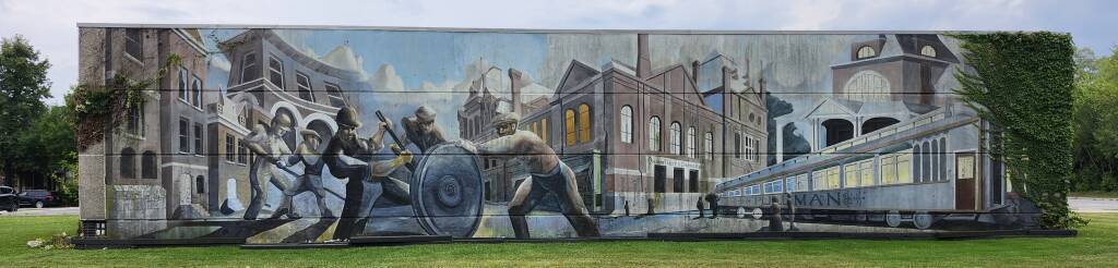 Mural depicting Pullman workers, finished car, factory, and company town.