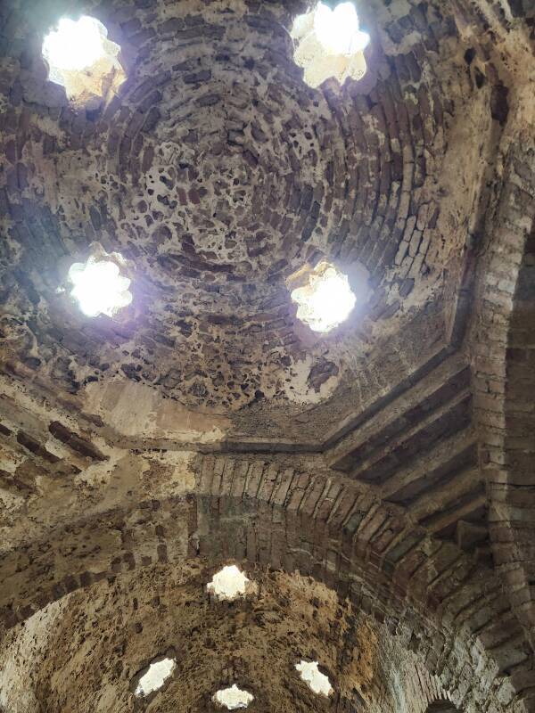 Warm Room with columns topped by horseshoe arches, supporting a vaulted ceiling with star-shaped skylights.