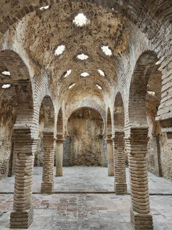 Warm Room with columns topped by horseshoe arches, supporting a vaulted ceiling with star-shaped skylights.