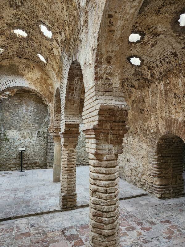 Warm Room with columns topped by horseshoe arches, supporting a vaulted ceiling with star-shaped skylights.
