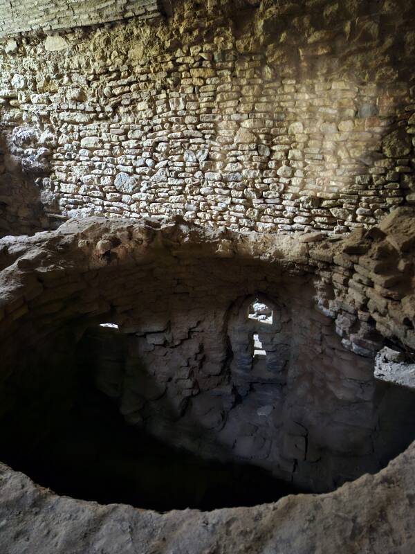 Light on a stone wall beyond the cylindrical water reservoir.