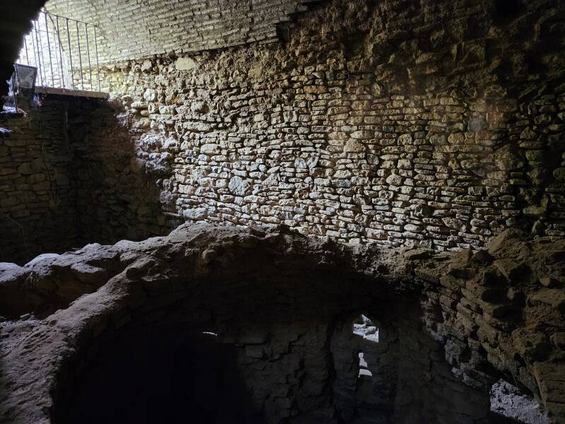 Light on a stone wall beyond the cylindrical water reservoir.