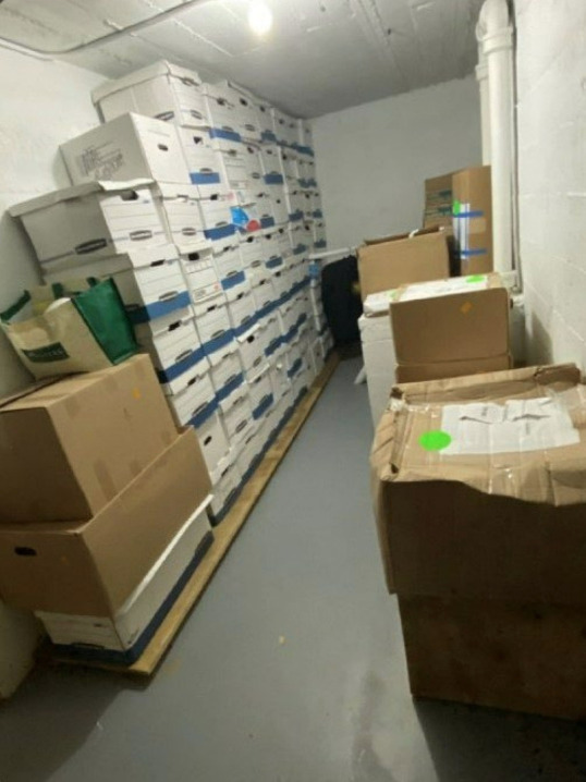 Boxes of highly sensitive U.S. Government documents piled around a photocopier in a storage room at a tacky golf resort.