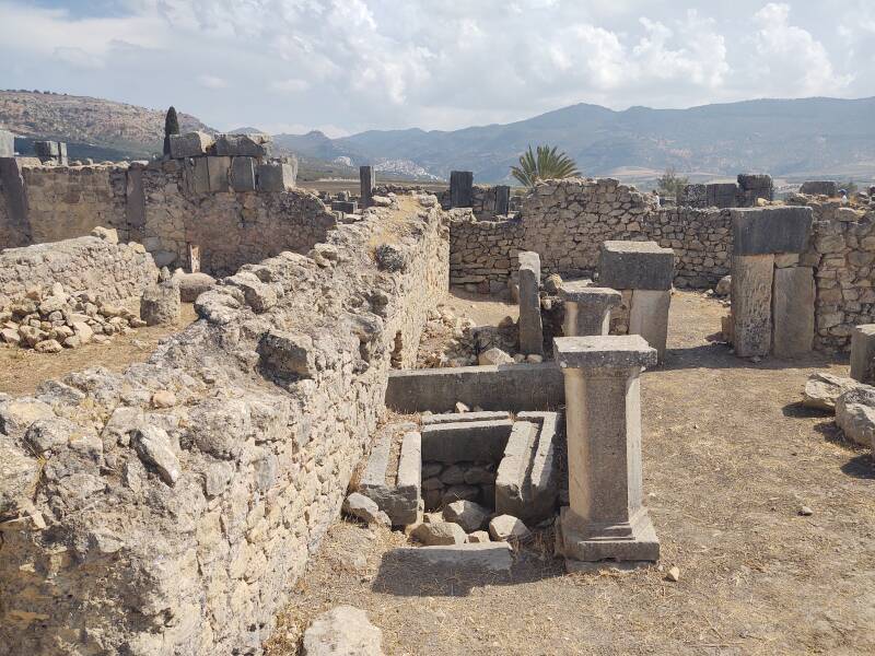 Latrine in the House of Dionysus at Volubilis, mountains and the town of Moulay Idris in the distance 5 kilometers away.